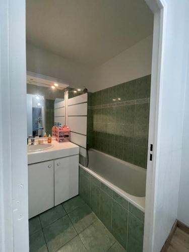 une salle de bain avec une baignoire et un lavabo et une baignoire dans l'établissement Appartement à 2 pas du Stade de France avec vue sur canal, à Saint-Denis