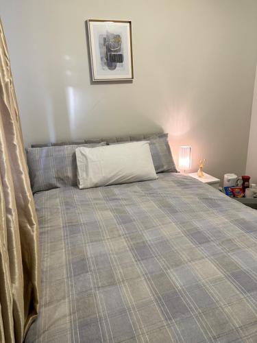 a bedroom with a bed with a plaid bedspread at Amazing Bedroom in Dublin in Clondalkin 