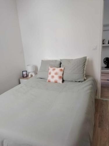 - un lit blanc avec un oreiller rose dans l'établissement Large 40m2 Prox Lille-métro-tram, à Roubaix