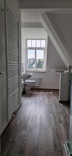 an attic room with a large window and a table at Ausblick Freital 2 in Freital