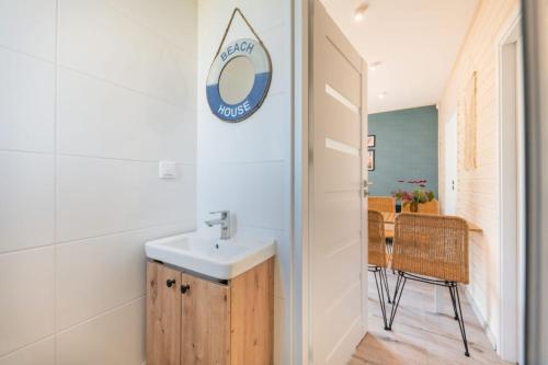 a bathroom with a sink and a mirror on the wall at MIELENKO BEACH - domki in Mielenko