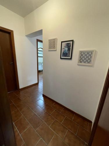 a hallway with a tile floor and two pictures on the wall at Caribean Praia das Toninhas - A 100 metros da areia 21A in Ubatuba