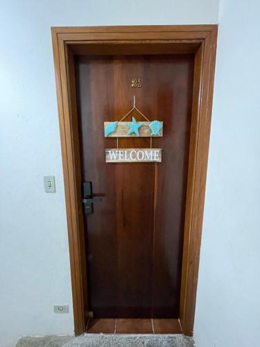 a welcome door with a welcome sign on it at Caribean Praia das Toninhas - A 100 metros da areia 21A in Ubatuba