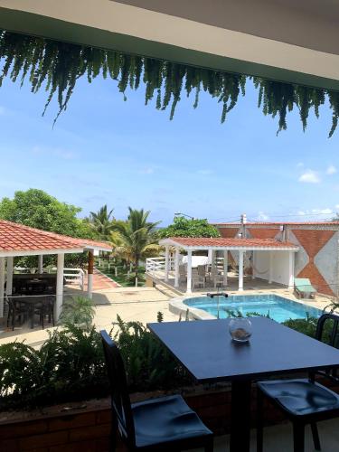 a patio with a table and chairs and a swimming pool at Hotel La Mar Playas in Playas