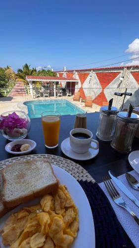 a table with a plate of breakfast food and a pool at Hotel La Mar Playas in Playas
