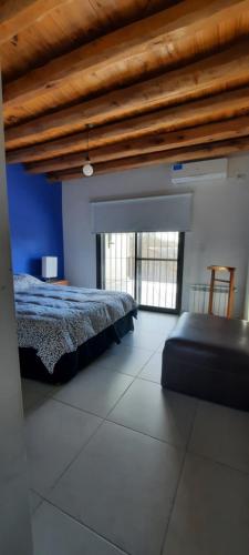 a bedroom with a bed and a couch in it at Como en Casa pero en Chacras in Ciudad Lujan de Cuyo