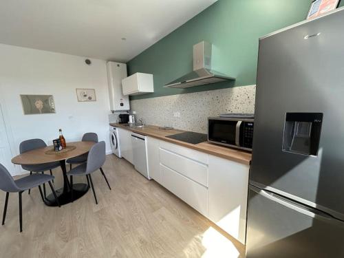 une petite cuisine avec une table et un réfrigérateur dans l'établissement Côté Mer - Superbe appartement centre de Binic, à Binic