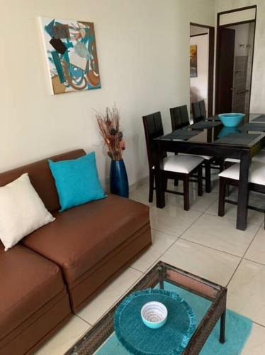 a living room with a brown couch and a table at Apartamento VillaRegis 1 Zapote, San José in San José