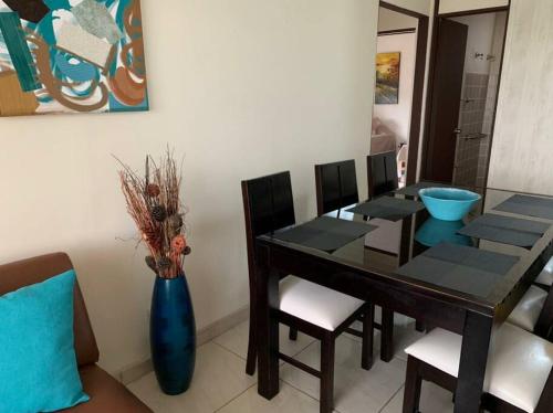 a dining room with a table and a blue vase at Apartamento VillaRegis 1 Zapote, San José in San José