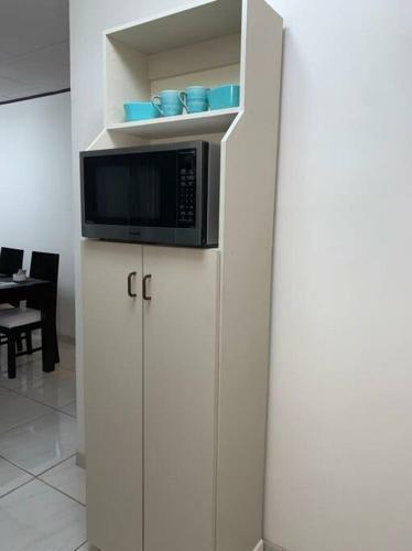 a microwave sitting on top of a white cabinet at Apartamento VillaRegis 1 Zapote, San José in San José