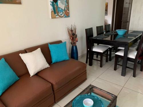 a living room with a brown couch and a table at Apartamento VillaRegis 1 Zapote, San José in San José