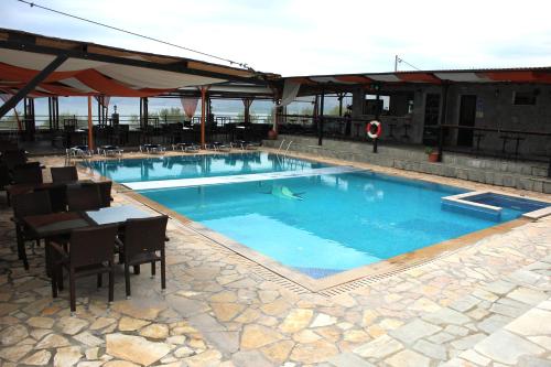 una gran piscina con mesa y sillas en Hotel Panorama, en Agios Panteleimon