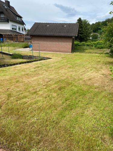 a large grassy yard with a house in the background at Ferienhaus fussläufig vom Biggesee in Attendorn