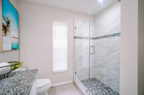 a bathroom with a glass shower with a toilet at Stylish Urban Haven, Cozy, Central in Lutz
