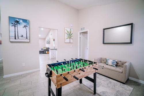 a foosball table in a living room with a couch at Stylish Urban Haven, Cozy, Central in Lutz