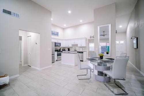 a kitchen with white walls and a table and chairs at Stylish Urban Haven, Cozy, Central in Lutz