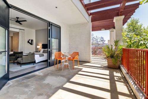 an outdoor patio with a table and chairs and a bedroom at Hotel Casa 425 + Lounge, A Four Sisters Inn in Claremont
