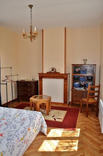 une chambre avec un lit, une table et un bureau dans l'établissement La maison d'Arthur et Armelène, à Rely