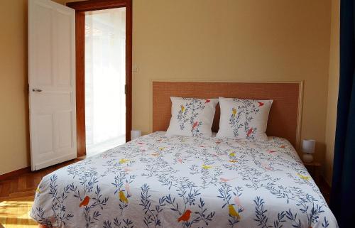 a bedroom with a bed with a bedspread with fishes on it at La maison d'Arthur et Armelène in Rely