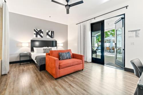 a bedroom with a bed and a chair at Hotel Casa 425 + Lounge, A Four Sisters Inn in Claremont