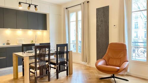une cuisine et une salle à manger avec une table et des chaises dans l'établissement 107 - Tour Eiffel Appartement luxe 15ème, à Paris