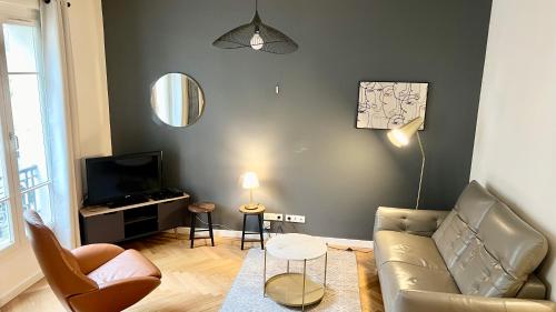 un salon avec un canapé et une télévision dans l'établissement 107 - Tour Eiffel Appartement luxe 15ème, à Paris