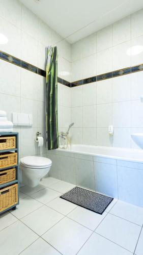 a bathroom with a toilet and a tub and a sink at Smiles Homes Appartement 52m2 im Hotel Mauritius - Privatparkplatz kostenfrei, Frühstück buchbar, direkt im Zentrum in Crimmitschau