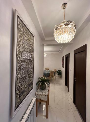 a hallway with a large painting on the wall and a chandelier at Suite Debussy in LʼAgha