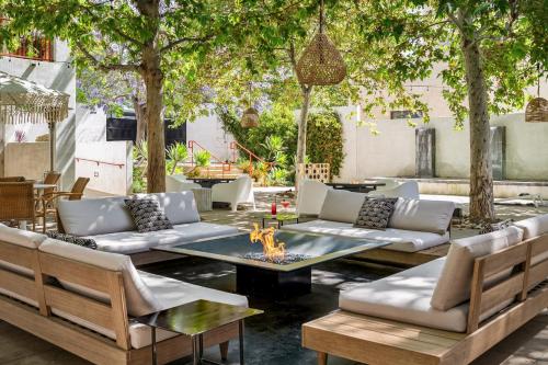 an outdoor patio with couches and a table and chairs at Hotel Casa 425 + Lounge, A Four Sisters Inn in Claremont