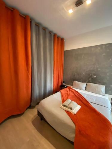- une chambre avec un lit et un rideau orange dans l'établissement Le Romainvillois-Terrasse aux portes de Paris, à Romainville