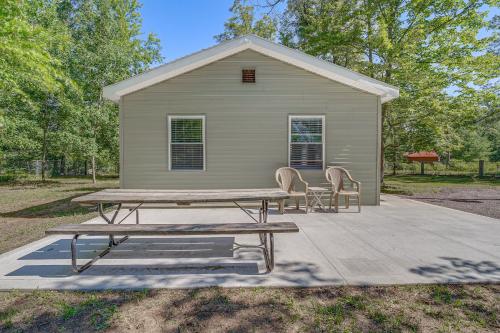 a picnic table and two chairs in front of a house at Fire Pit and Patio Pet-Friendly Cabin in Idlewild! in Idlewild