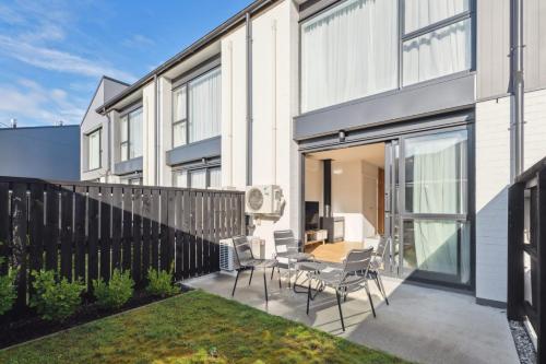 a patio with a table and chairs and a fence at Alpine Escape Apartment in Albert Town