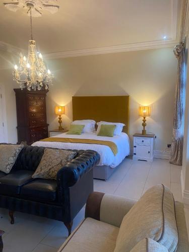a bedroom with two beds and a couch at St Columbs House in Buncrana