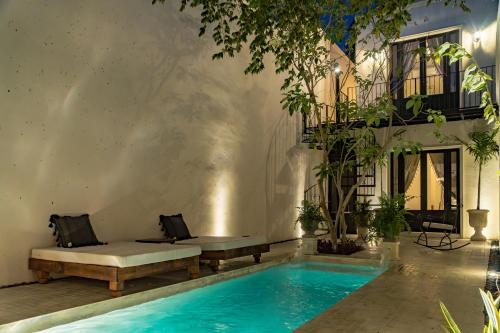 una piscina con panchina accanto a un edificio di Luxury Historic 5BR Boutique hotel in Centro Walkable & Pool a Mérida