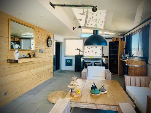 un salon avec une table et une cuisine dans l'établissement La londe les Maures Location saisonnière Grand Toit-Terrasse, à La Londe-les-Maures