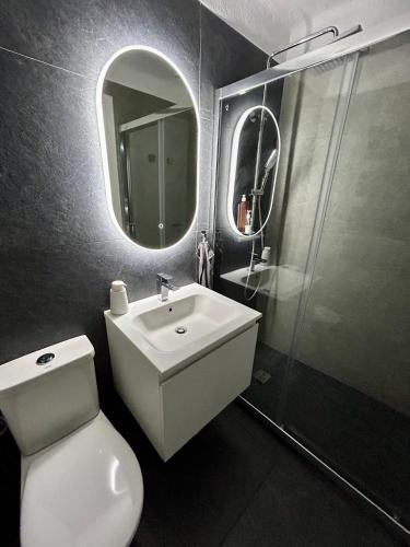 une salle de bain avec un lavabo, des toilettes et un miroir dans l'établissement Classic Confort Suites, à Vallauris