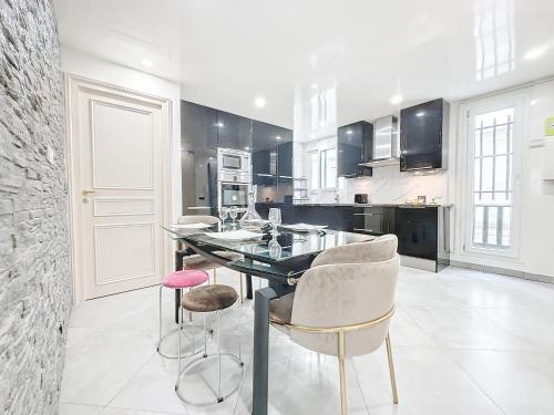 une cuisine avec une table et quelques chaises dans l'établissement 118 - Paris , Place de la République, 7 personnes, à Paris