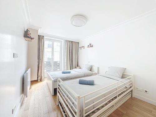 - une chambre blanche avec 2 lits et une télévision dans l'établissement 118 - Paris , Place de la République, 7 personnes, à Paris