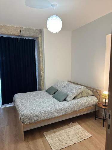 - une chambre avec un lit et une lampe pendant dans l'établissement Appartement Centre ville Besançon, à Besançon