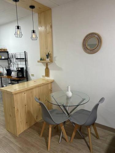 a glass table and two chairs in a kitchen at Apartamento VillaRegis 3 PB, Zapote, San Jose in San José