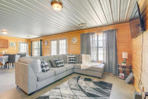 a living room with a couch and a table at 5 Mi to Sardis Lake Pet-Friendly Cabin Rental in Batesville