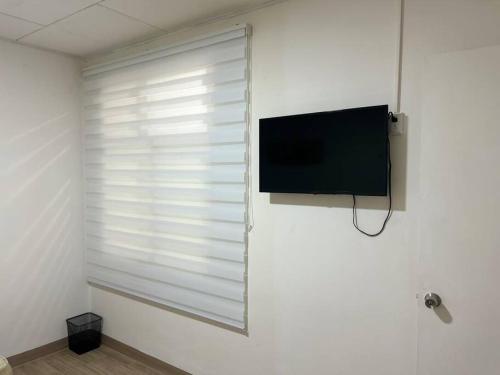 a room with a window with a flat screen tv at Apartamento VillaRegis 3 PB, Zapote, San Jose in San José