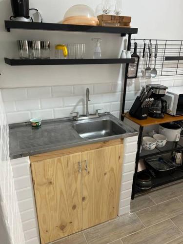 a kitchen with a sink and a shelf with utensils at Apartamento VillaRegis 3 PB, Zapote, San Jose in San José