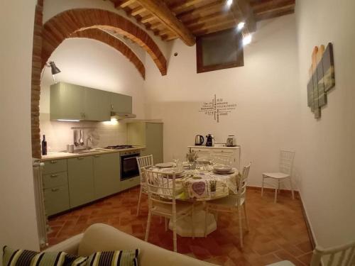 a kitchen with a table and a kitchen with a table and chairs at Casa Torre Borgo dei Borghi in Peccioli