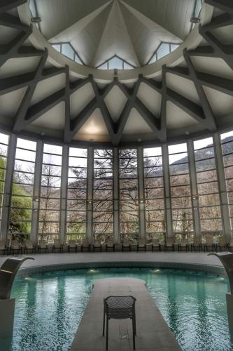 - une piscine avec une chaise dans un bâtiment dans l'établissement BEL APPARTEMENT LUCHON CENTRE WIFI - CLIMATISATION 6 COUCHAGES, à Luchon