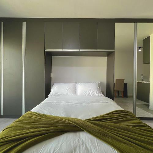 a bedroom with a large bed with a green blanket on it at Studio Prime 1510 - Higienópolis in Sao Paulo