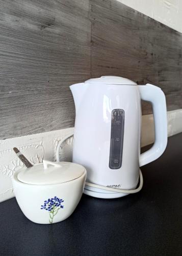 a white tea kettle and a bowl on a table at Apartaments Gory in Niedzica Zamek