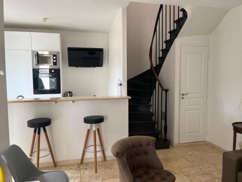 Il comprend une cuisine et un salon avec un escalier en colimaçon. dans l'établissement Maison Colombes, à Colombes