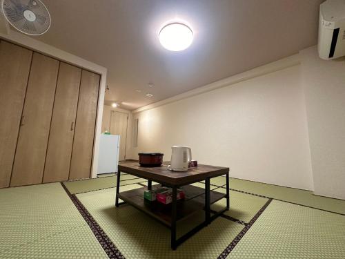 a room with a table with a appliance on it at 駅本ビル民宿 in Yuzawa