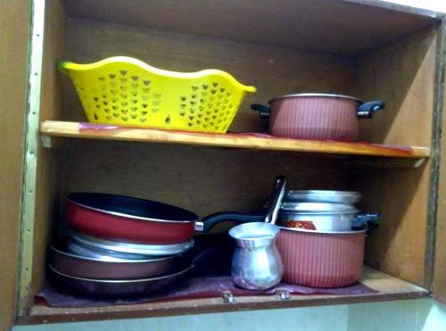 a shelf with pots and pans and a yellow basket at La Veranda 陽台 in Aswan